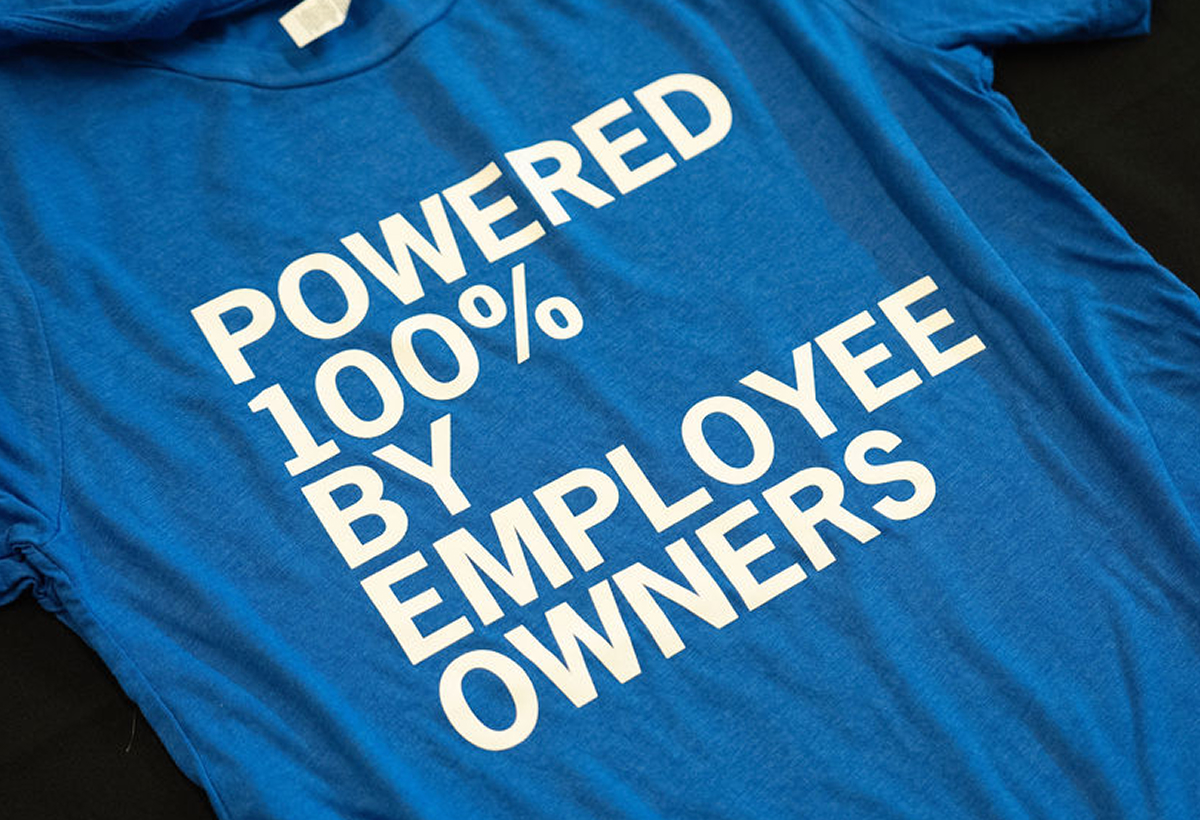 Blue t-shirt reading Powered 100% by Employee Owners